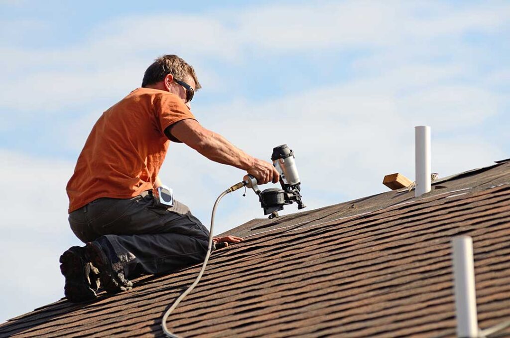 Metal flashing directs water around a chimney and roof shingles on a residential home.