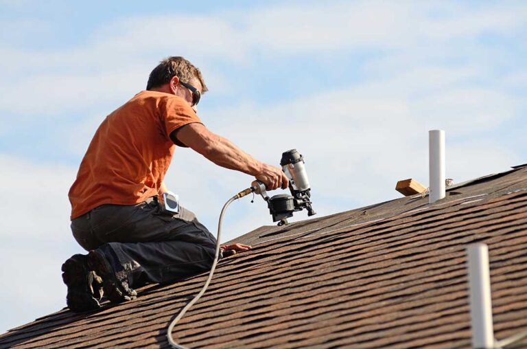 Metal flashing directs water around a chimney and roof shingles on a residential home.